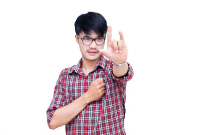 Portrait of teenage boy standing against white background