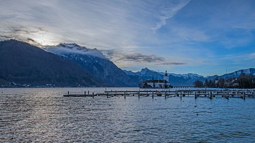 Scenic view of lake by snowcapped mountains against sky