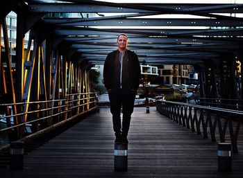 Portrait of mature man standing on footbridge