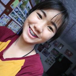 Portrait of smiling teenager girl with braces at home