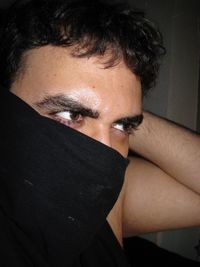 Close-up of man hiding face with black fabric