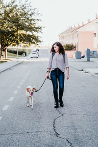 Woman with dog standing on street