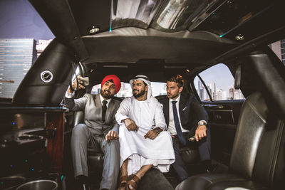 Businessmen doing selfie while sitting in car