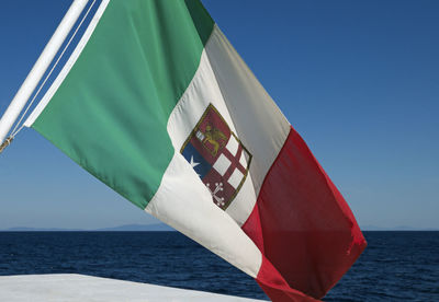 Low angle view of flag against blue sky