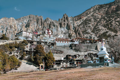 View of trees and houses against mountain range