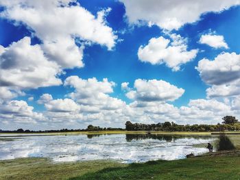 Scenic view of river against cloudy sky