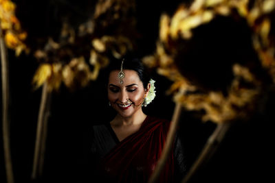 Portrait of smiling young woman wearing traditional clothing at night