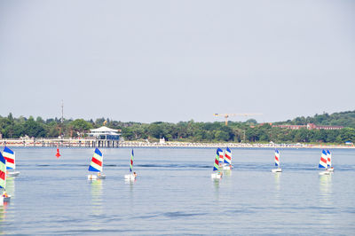 Boats in sea against clear sky