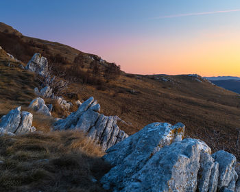 Scenic view of rocky mountains against sky during sunset