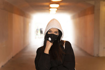 Portrait of woman standing against illuminated wall