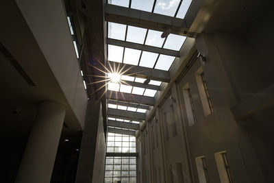 Low angle view of sunlight streaming through window in building