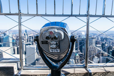 Coin-operated binoculars with cityscape in background