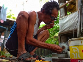 There is a grandfather who is working on stones