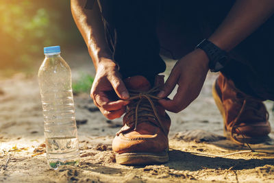 Low section of man drinking water from bottle