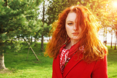 Beautiful woman in red coat on the background of the park