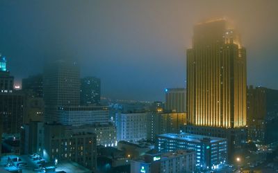 Illuminated cityscape against sky at night