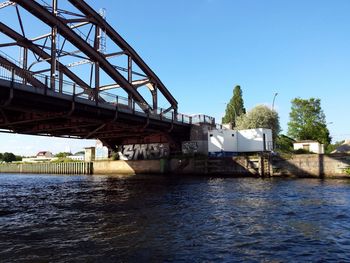 Bridge over river against clear blue sky