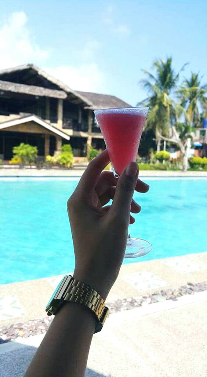 MIDSECTION OF WOMAN DRINKING WATER IN POOL