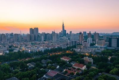 Aerial view of buildings against sky during sunset