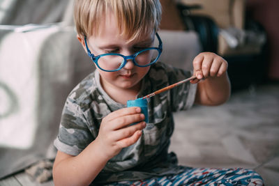 Close-up of boy drawing with paint