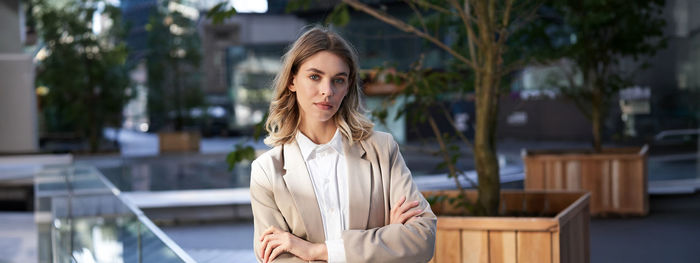 Young woman looking away while standing outdoors