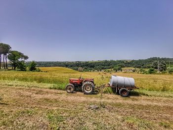 Tractor on field against clear sky