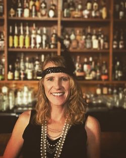 Portrait of smiling mid adult woman against bar counter