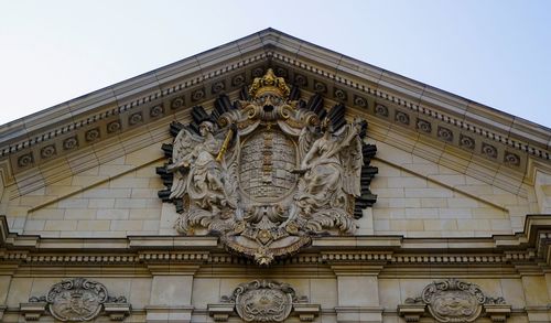 Low angle view of statues on building against sky