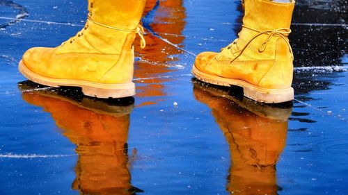 Low section of person with reflection in puddle