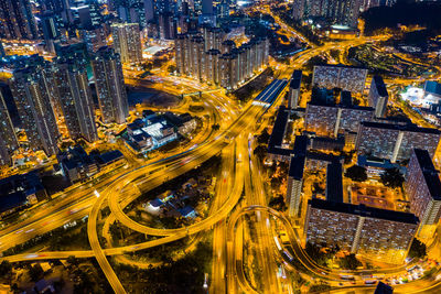 Aerial view of light trails on elevated road in illuminated city at night