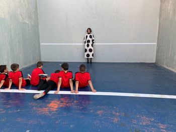 Rear view of people playing piano against wall