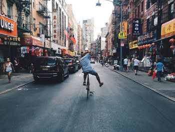 Rear view of man cycling in chinatown