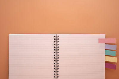 Open book on table against orange background