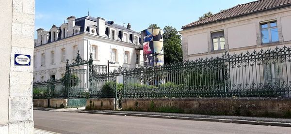 Road by building against sky