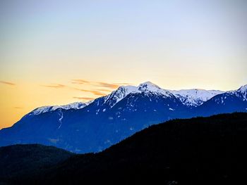 Scenic view of snowcapped mountains against sky during sunset