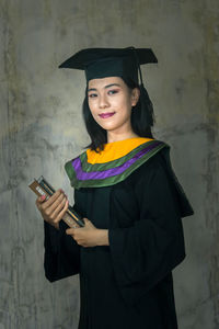 Portrait of a smiling young woman holding smart phone