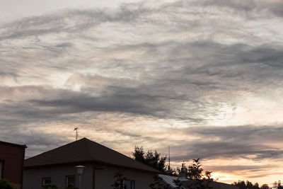 Low angle view of buildings against cloudy sky