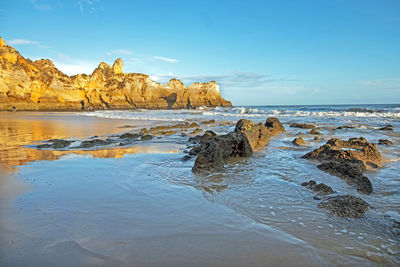 Rocks on beach against sky