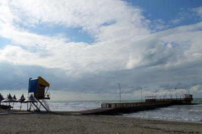 Lifeguard hut on beach against sky