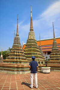 Visitor being impressed by the group of pagodas in wat pho temple, bangkok, thailand