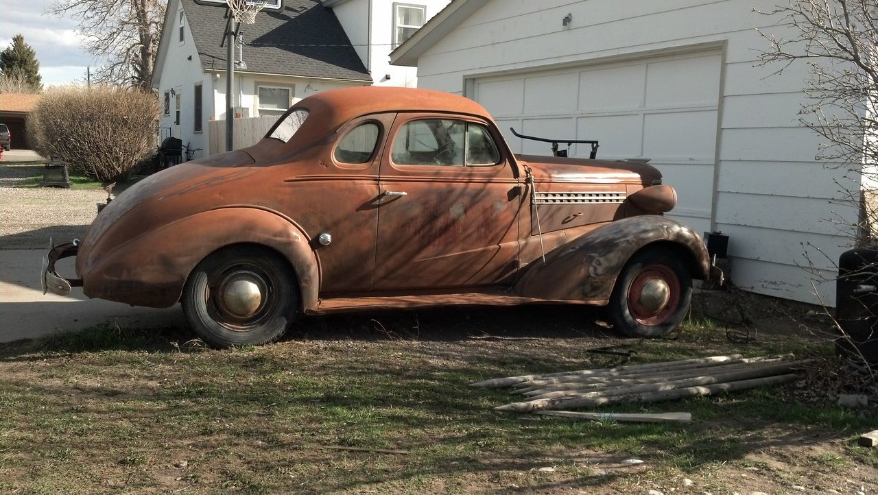 transportation, land vehicle, mode of transport, car, stationary, building exterior, built structure, field, abandoned, architecture, street, outdoors, vintage car, wheel, day, old-fashioned, sunlight, old, sky, tractor