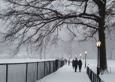 People walking on snow covered footpath during winter