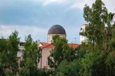 Panoramic view of trees and buildings against sky