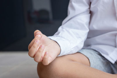 Midsection of boy doing yoga at home