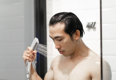 Portrait of shirtless man in bathroom