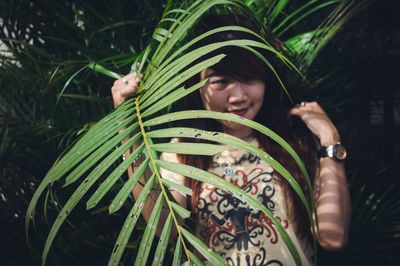 Woman looking away by plants