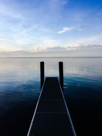 Pier over sea against blue sky