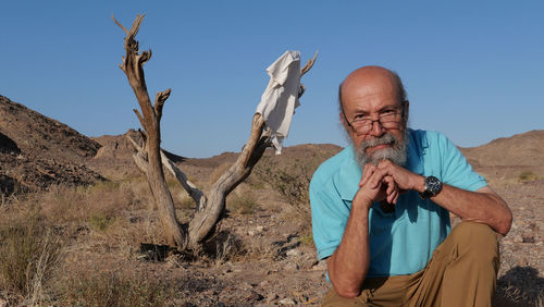 Senior man sitting in the desert 
