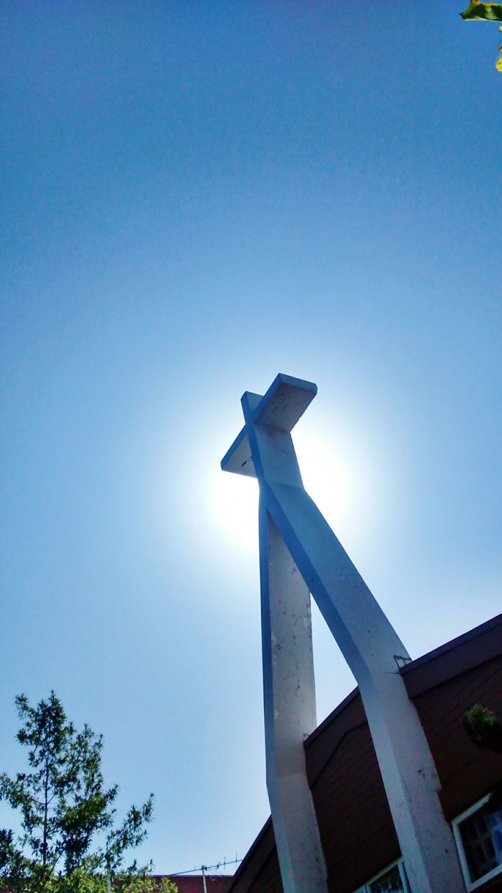 clear sky, low angle view, blue, copy space, built structure, architecture, sunlight, architectural column, statue, sculpture, day, outdoors, monument, no people, tree, column, building exterior, sky, high section, travel destinations