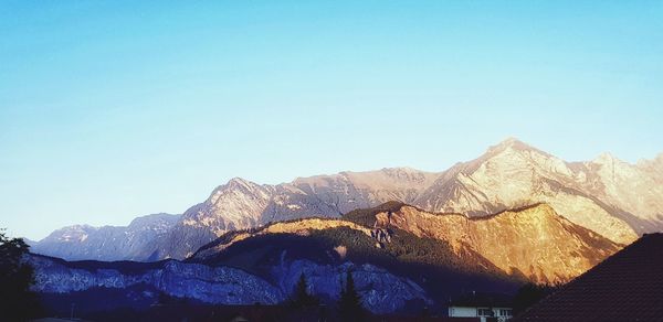 Scenic view of snowcapped mountains against clear blue sky